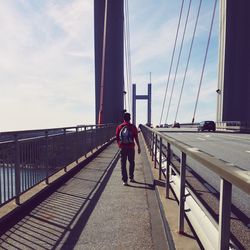 Rear view of woman walking on bridge