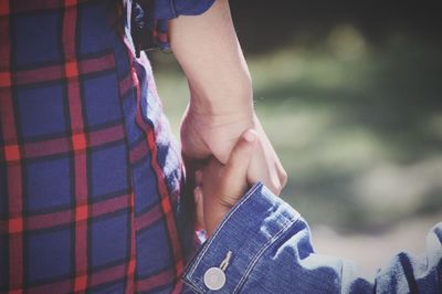 Cropped hand of mother holding daughter