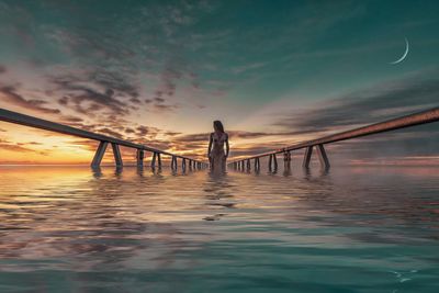 Man on beach against sky during sunset