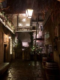 Illuminated alley amidst buildings in city at night