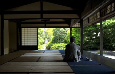 Man sitting in corridor of building