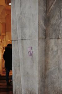 Rear view of person standing against wall