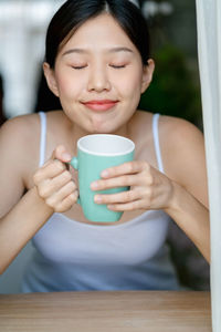 Woman with eyes closed drinking coffee