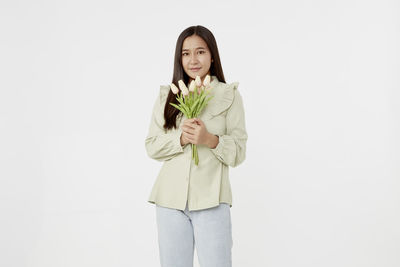 Portrait of a smiling young woman over white background