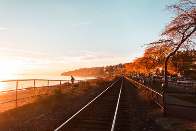 View of railroad tracks against sky during sunset