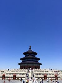 Tourists against clear blue sky