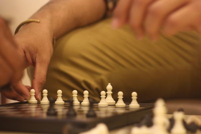 Midsection of man playing chess at home