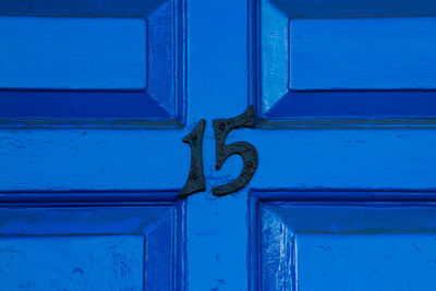 House number 15 on a blue wooden front door in london 
