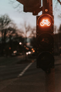 Close-up of illuminated lighting equipment on road at night