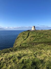 Lighthouse by sea against sky