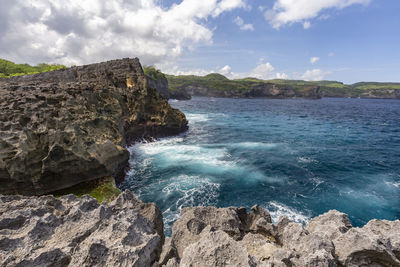 Scenic view of rocks in sea against sky