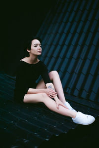 Beautiful young woman sitting on roof