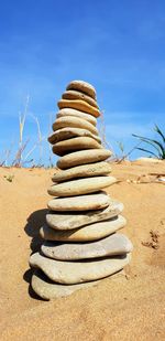 Stack of stones on beach against sky