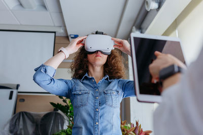 Woman with curly hair trying on vr in the office