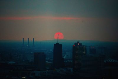Aerial view of buildings in city during sunset