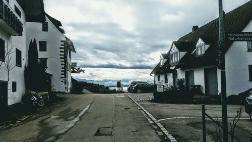 Road amidst buildings against sky