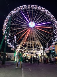 People in amusement park ride at night