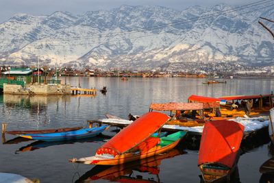 Boats moored in lake against mountain range