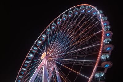 Low angle view of illuminated ferris wheel against sky at night