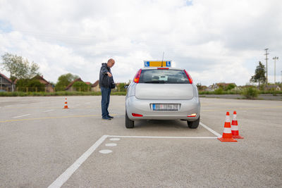 Instructor explaining candidate how to better park a car on the polygon with cones.