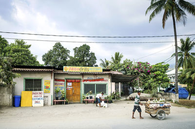 People riding motorcycle on street against buildings