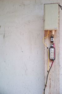 Electrical outlet supply and breaker installed on the wooden plate with the plastered cement.