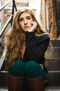 Portrait of young woman sitting on steps