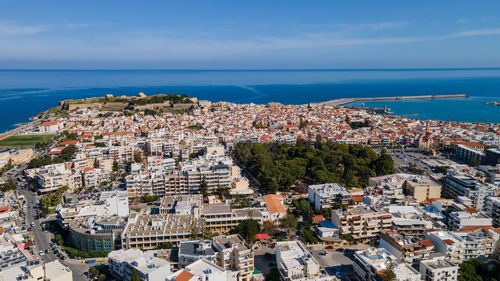 High angle view of townscape by sea against sky