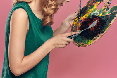 Midsection of woman holding multi colored painting