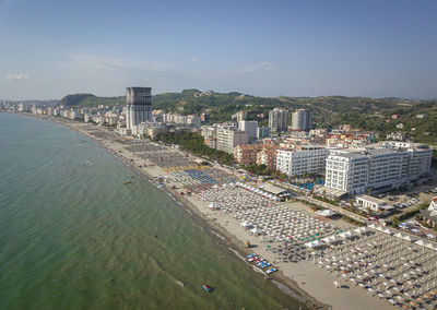 High angle view of city by sea against sky