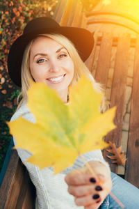 Portrait of a smiling young woman holding hat