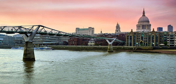 Bridge over river in city against sky