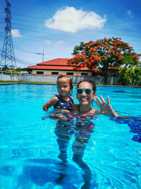 Portrait of mother and little daughter in swimming pool