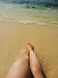 Low section of woman relaxing on beach