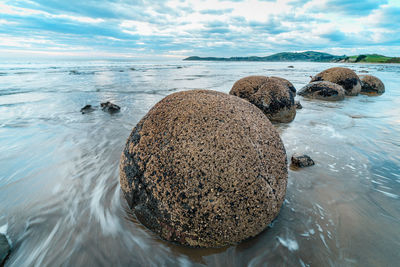 Scenic view of rocks on beach against sky