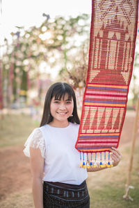 Portrait of young woman standing by colorful decorations