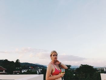 Portrait of woman standing against sky