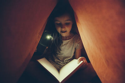 Portrait of girl sitting on book