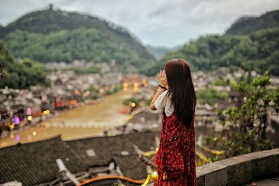 Woman standing on mountain against sky