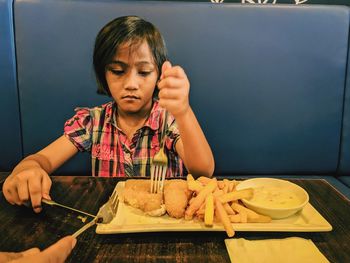 Boy holding food on table