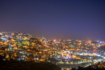 Illuminated cityscape against sky at night