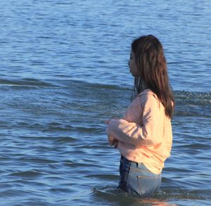 Rear view of woman standing in lake