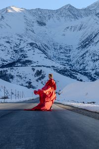 Rear view of woman walking on snow covered mountain