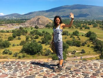 Full length of young woman standing on mountain