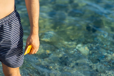 Midsection of man standing at beach