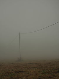 Electricity pylon on field against sky