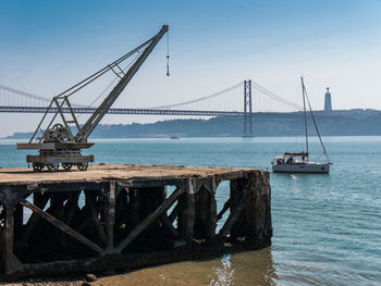 Suspension bridge over sea against sky