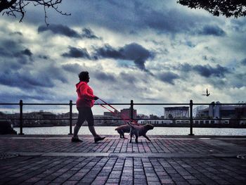 Silhouette of woman against cloudy sky