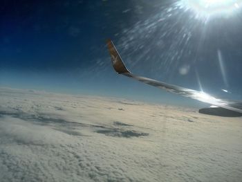 Airplane flying over snowy landscape against sky