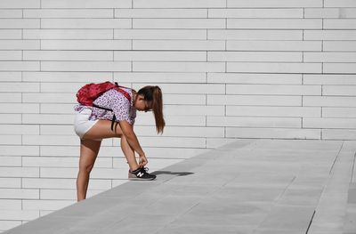 Side view of woman against wall